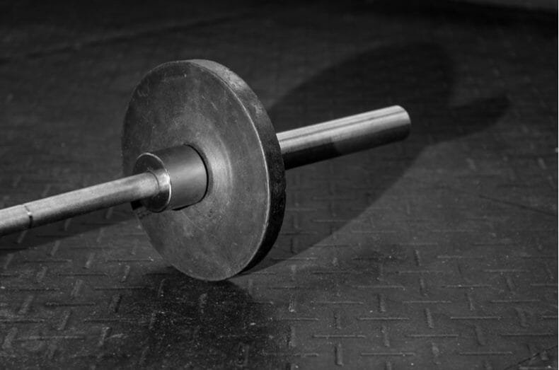 loaded barbell on rubber gym floor mats