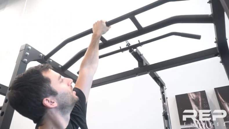 man showing both pull up bars of rep pr 1100 power rack