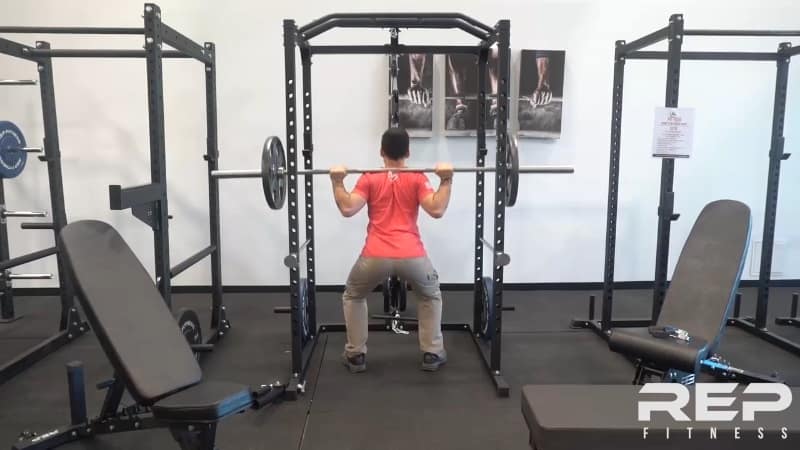 rep fitness showroom Man lifting barbell in rep power rack showroom