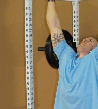man performing a chin up on tds power rack