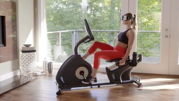 woman using VR on recumbent woman enjoying VR while cycling on schwinn recumbent