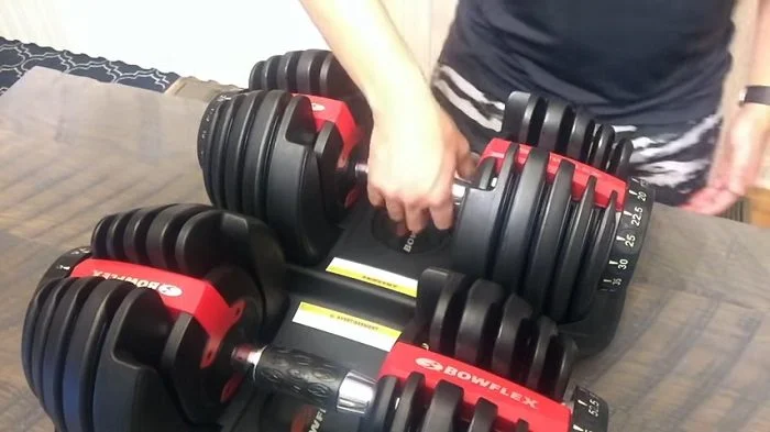 pair of bowflex 552 dumbbells in their cradles on a table