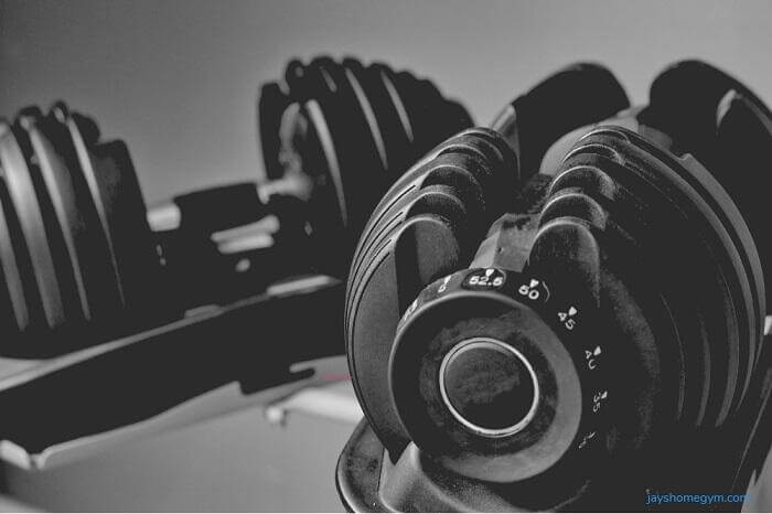 pair of adjustable dumbbells two dumbbells on stands in a home gym