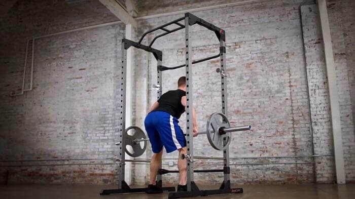 man perfroming bent over barbell rows inside fitness reality 810XLT power cage