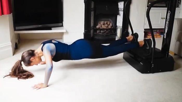 woman performing push - ups on vibration plate
