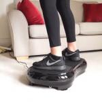 fit woman standing on vibration machine in her front room