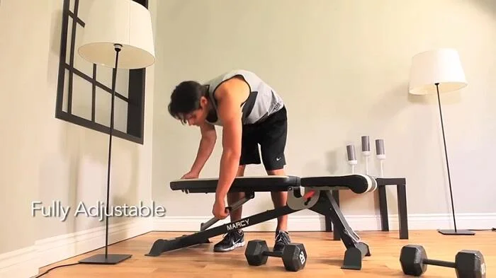 man adjusting marcy weight bench to flat position