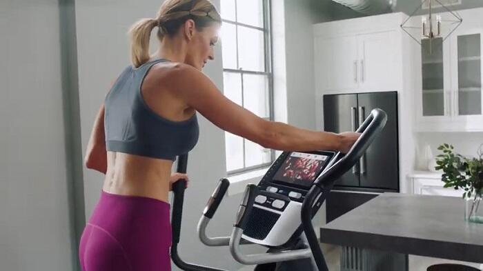 woman exercising on elliptical in her kitchen elliptical workout in kitchen