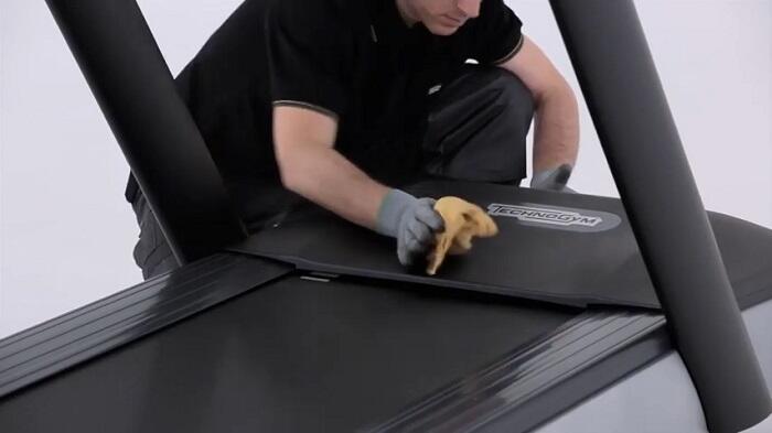 How to clean your Technogym treadmill dusting man dusting his treadmill