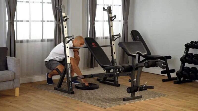 best Marcy Olympic Weight Bench - MD-857 man loading weight plates on Marcy Olympic weight bench