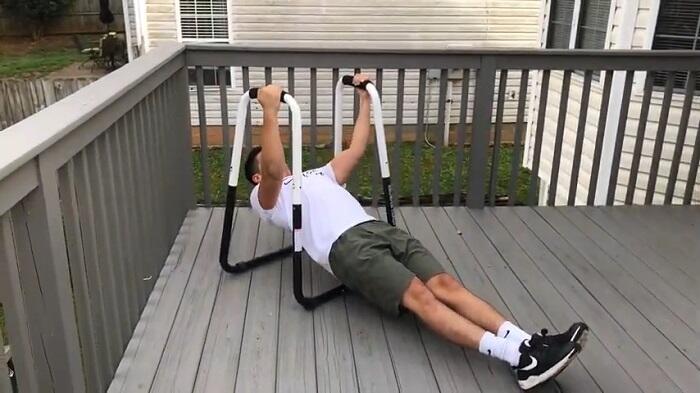 man performing body weight rows on ultimate body press dip station