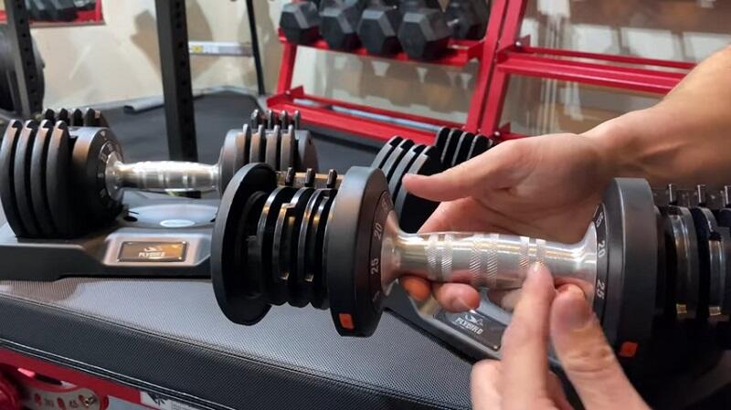 man holding flybird 25lb dumbbell in his home gym