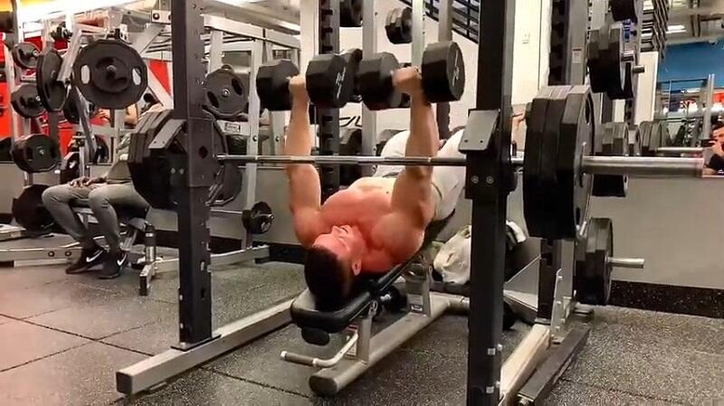 decline dumbbell press commercial gym man performing decline dumbbell press