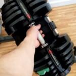 Bowflex 1090 adjustable dumbbells on stand in front room of house