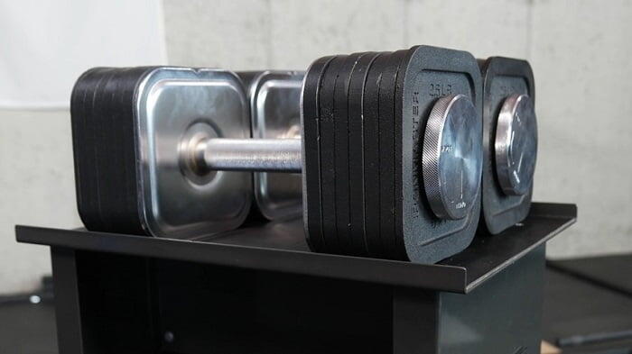 pair of ironmaster adjustable 75lb dumbbels on stand with weight plates