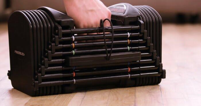 single powerblock pro 50 dumbbell man holding single powerblock pro 50 adjustable dumbbell
