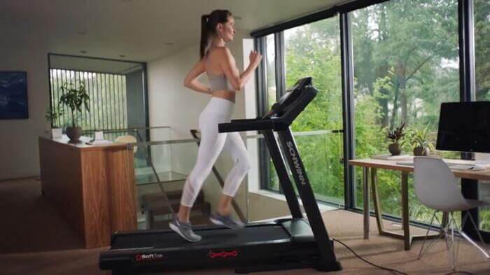 side view of woman jogging on Schwinn 810 treadmill