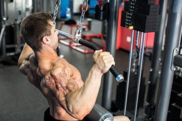 man performing lat pulldowns in a gym