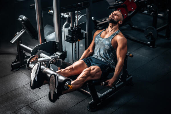 fit man doing leg exercises on a machine