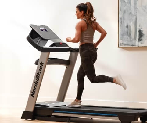 side view of woman running of exp 7i treadmill