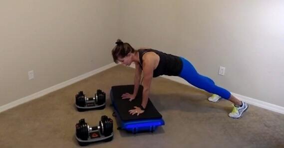 vibration plate push ups woman performing push ups on vibration plate