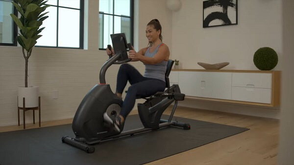 woman using schwinn recumbent app woman using schwinn recumbent and fitness app