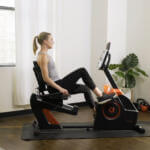 woman pedaling on a budget recumbent exercise bike