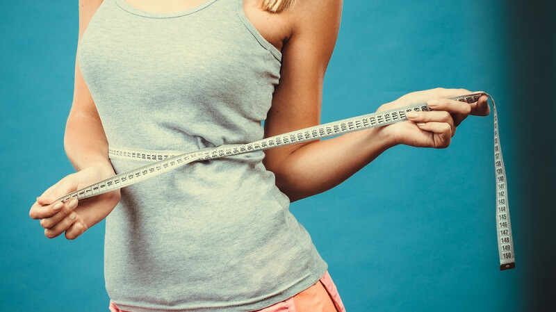 weight loss with walking fit woman with measuring tape around waist