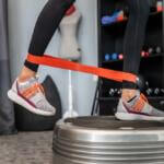 woman using vibration plate with exercise bands
