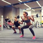 man and woman performing barbell squats