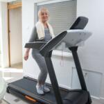 senior woman walking on her treadmill at home
