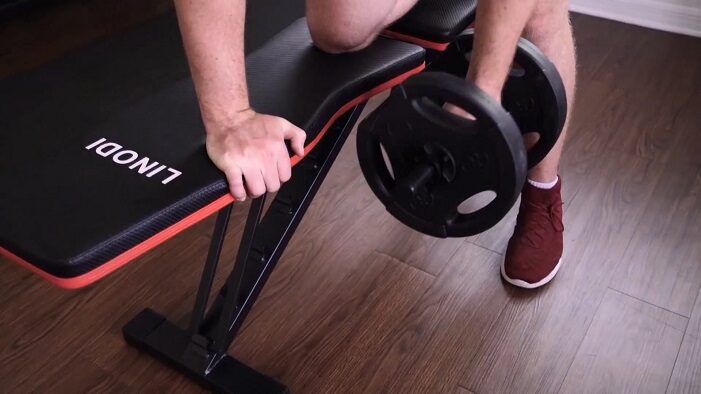 man performing dumbbell rows on linodi weight bench