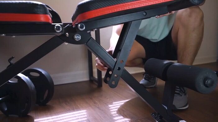 man adjusting linodi weight bench seat