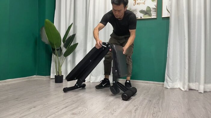 man folding the leikefitness weight bench