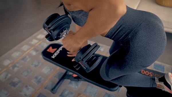 woman performing dumbbell rows on keppi weight bench
