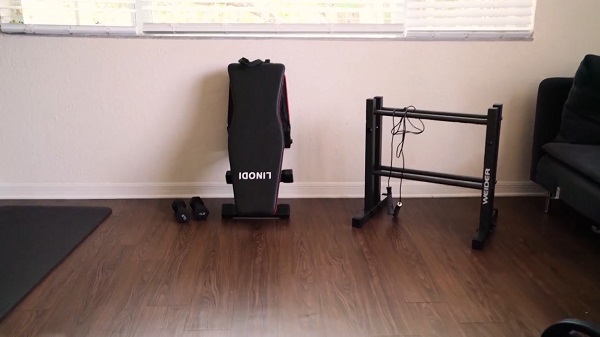 linodi weight bench folded in a home gym