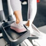 woman walking on an elliprical trying to lose weight in her home gym